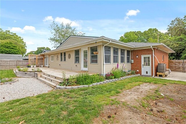 view of front of house with fence, a garden, a patio area, and a front yard