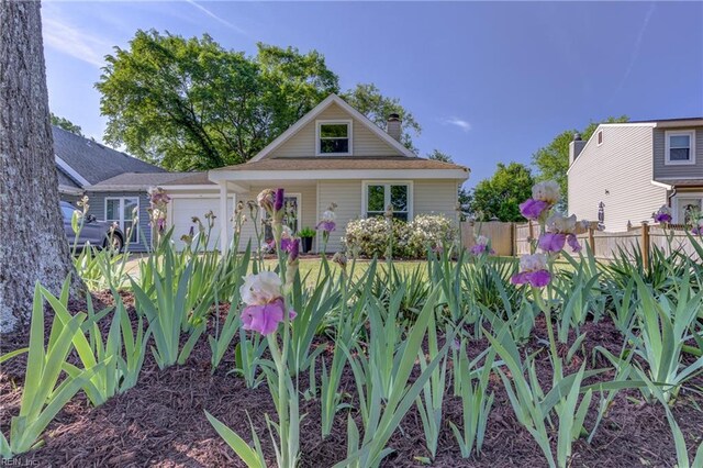 bungalow-style home featuring fence, an attached garage, and a chimney