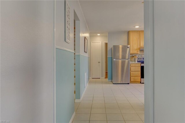 hallway featuring light tile patterned floors, baseboards, and recessed lighting