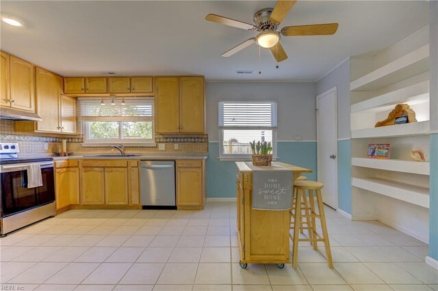kitchen with decorative backsplash, stainless steel appliances, a wealth of natural light, and a sink