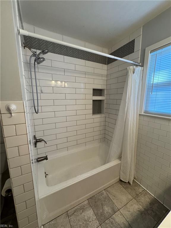 full bathroom with tile patterned flooring and shower / tub combo with curtain