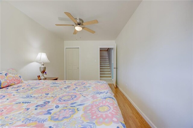 bedroom featuring a closet, a ceiling fan, light wood-style flooring, and baseboards