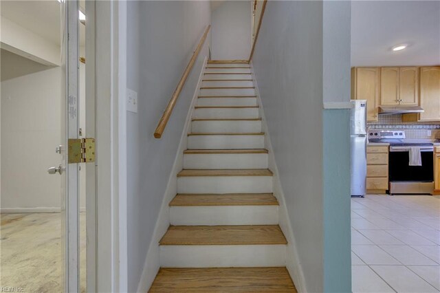 stairs featuring baseboards and tile patterned floors