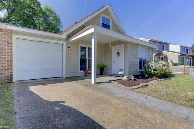 view of front of house with fence, an attached garage, and driveway