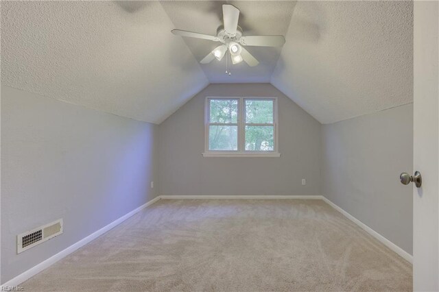 additional living space featuring a ceiling fan, carpet flooring, a textured ceiling, and visible vents