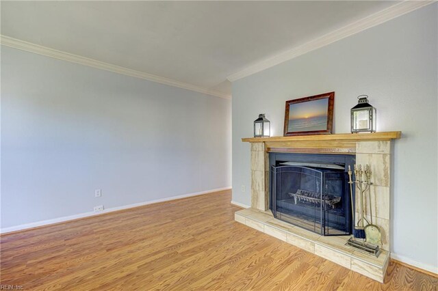 unfurnished living room with crown molding, baseboards, wood finished floors, and a tile fireplace