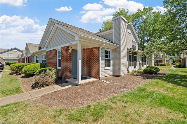 view of property exterior featuring a yard, brick siding, and a chimney
