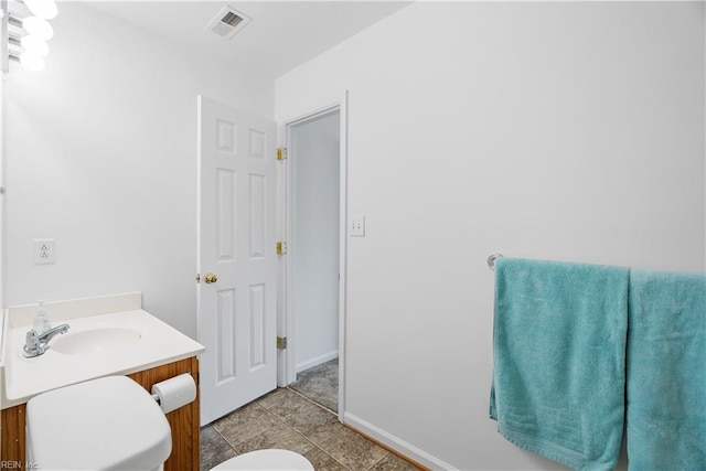 bathroom with visible vents, vanity, toilet, baseboards, and tile patterned floors