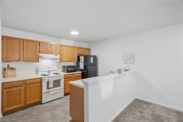 kitchen featuring brown cabinetry, a peninsula, light countertops, under cabinet range hood, and black appliances