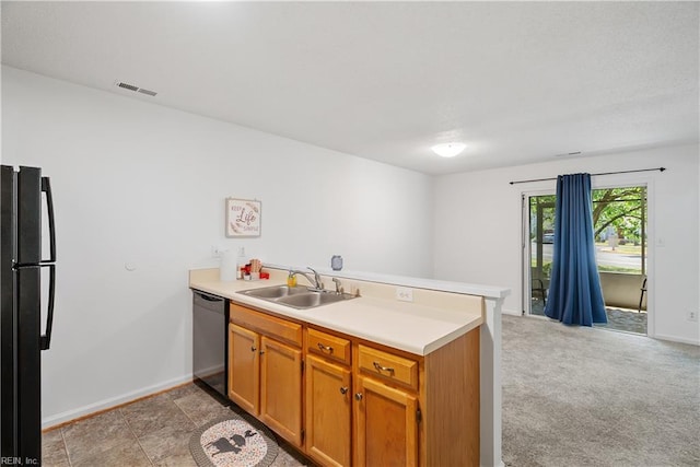 kitchen with a sink, dishwasher, freestanding refrigerator, a peninsula, and visible vents