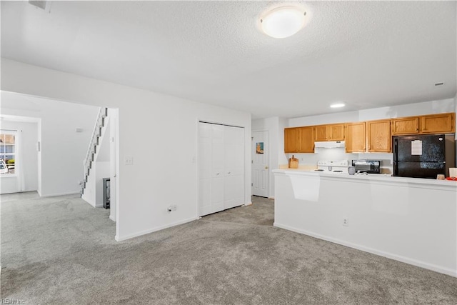 kitchen with freestanding refrigerator, light carpet, stove, light countertops, and under cabinet range hood