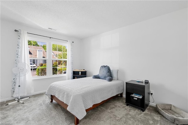 carpeted bedroom with visible vents, a textured ceiling, and baseboards