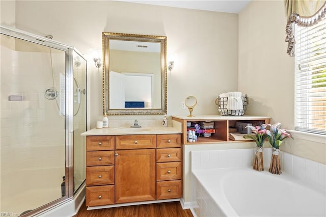 bathroom featuring a bathtub, a shower stall, wood finished floors, and vanity