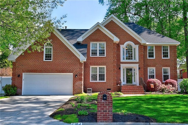 colonial inspired home with a front yard, a garage, central air condition unit, brick siding, and concrete driveway