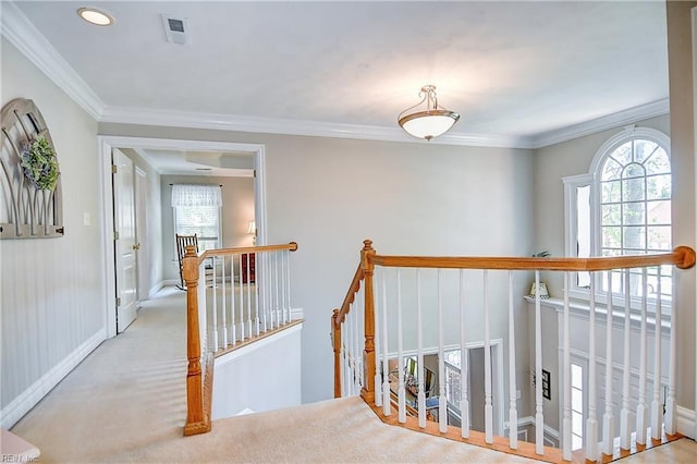 hallway with visible vents, baseboards, crown molding, and an upstairs landing