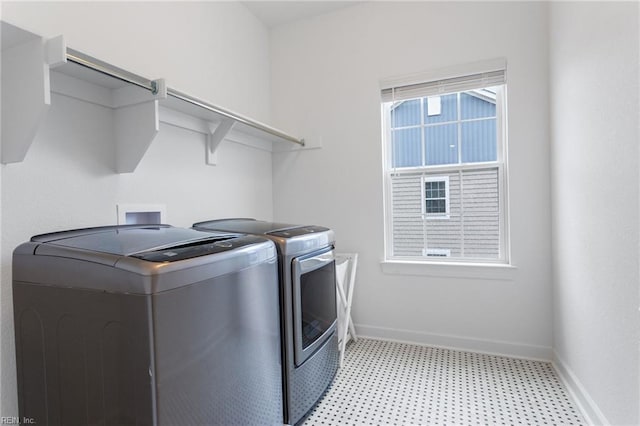 laundry area featuring light floors, baseboards, laundry area, and washing machine and dryer
