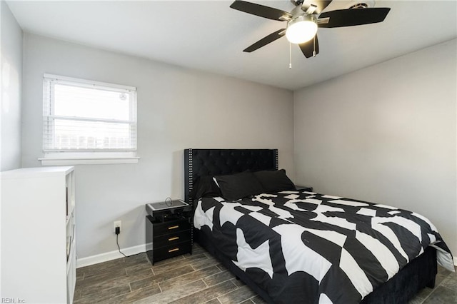 bedroom featuring dark wood-style floors, baseboards, and a ceiling fan