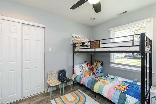 bedroom with wood finished floors, ceiling fan, and a closet