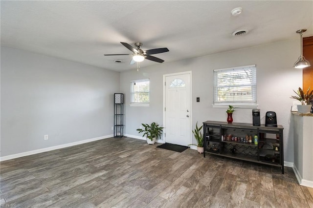 foyer with ceiling fan, wood finished floors, and baseboards