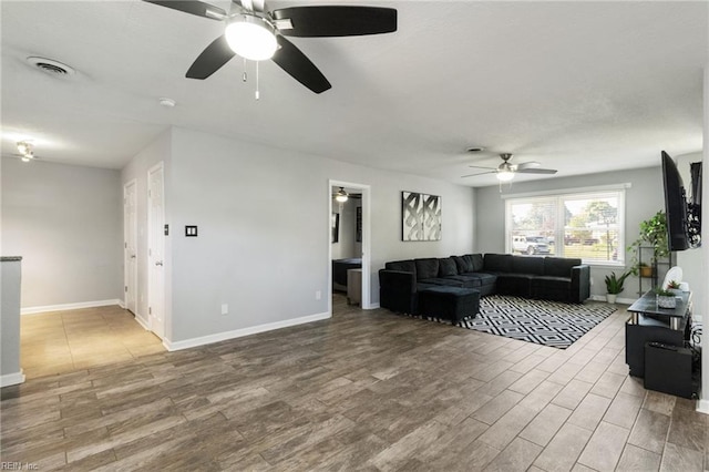living room with ceiling fan, wood finished floors, and baseboards