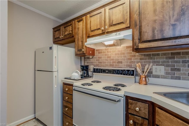 kitchen featuring crown molding, decorative backsplash, white appliances, light countertops, and under cabinet range hood