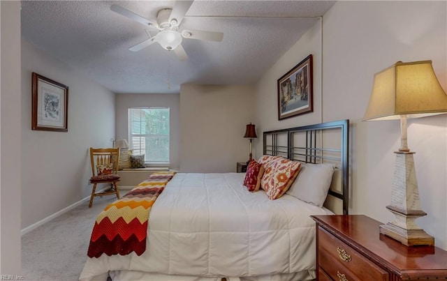 carpeted bedroom featuring baseboards, a ceiling fan, and a textured ceiling