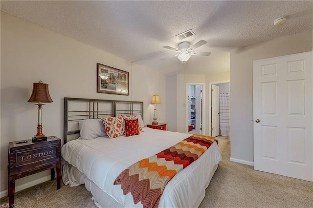 bedroom with carpet flooring, a textured ceiling, ceiling fan, and visible vents