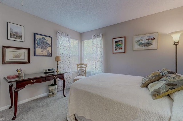 bedroom featuring carpet flooring, a textured ceiling, and baseboards