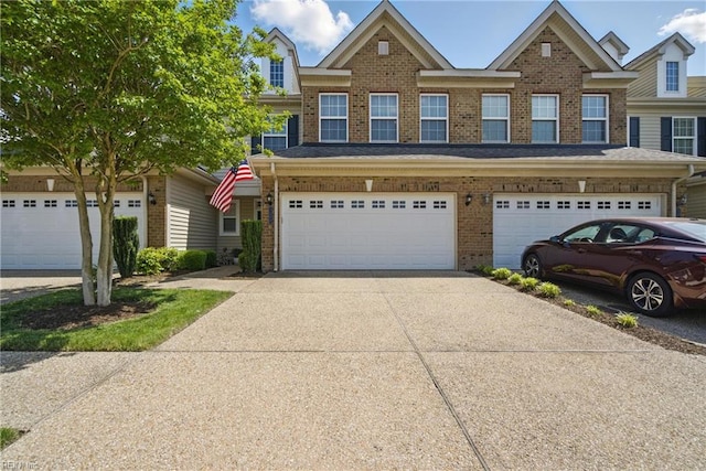 multi unit property with brick siding, driveway, and a garage