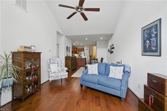 living area with ceiling fan, visible vents, wood finished floors, high vaulted ceiling, and baseboards