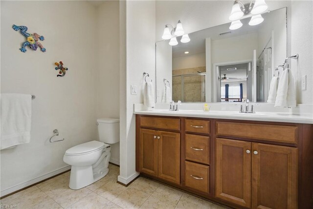 bathroom featuring double vanity, a stall shower, a sink, toilet, and a notable chandelier