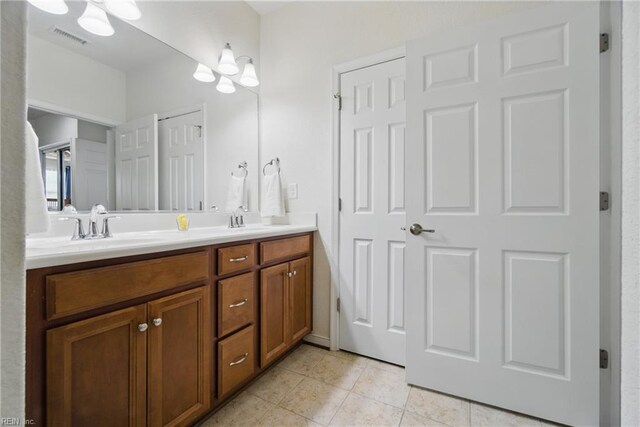 bathroom featuring a sink, tile patterned flooring, double vanity, a chandelier, and visible vents