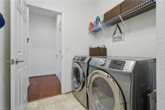 laundry area with laundry area, baseboards, and independent washer and dryer