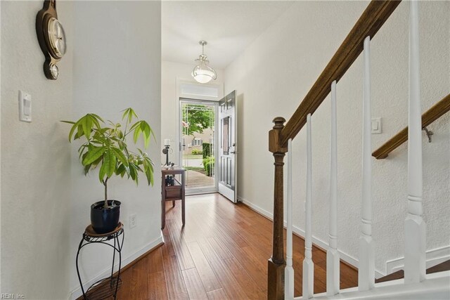 foyer featuring stairs, baseboards, and wood-type flooring