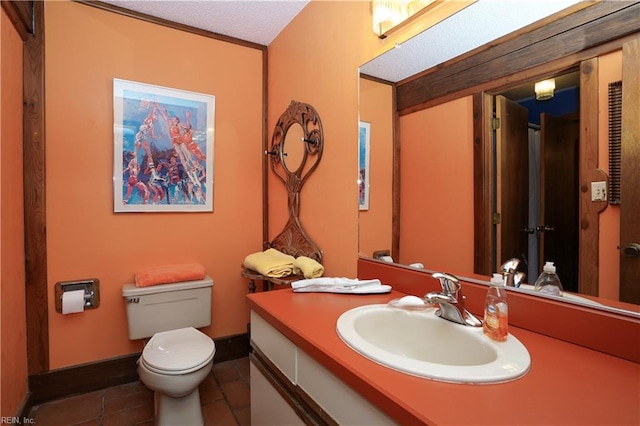 bathroom with tile patterned flooring, vanity, toilet, a textured ceiling, and baseboards
