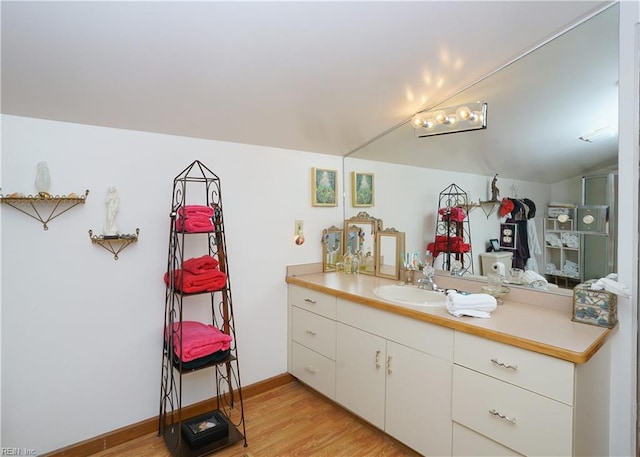 bathroom featuring vanity, baseboards, and wood finished floors