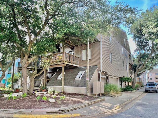 view of side of home featuring a deck and a garage