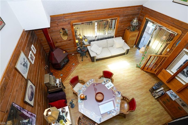 living room with a wood stove and wood walls