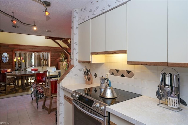 kitchen featuring light countertops, stainless steel range with electric cooktop, white cabinetry, and tasteful backsplash