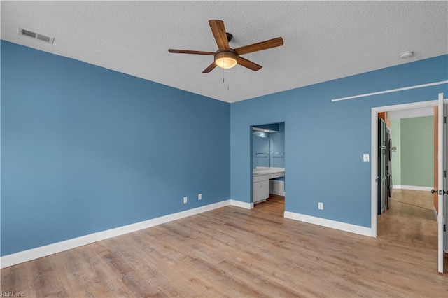 unfurnished bedroom with baseboards, a textured ceiling, visible vents, and light wood-style flooring