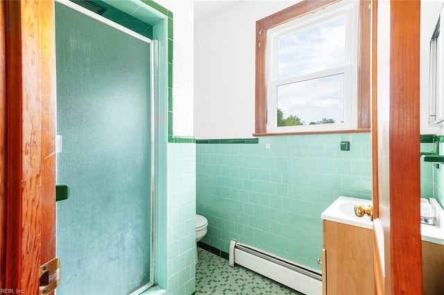 full bathroom featuring vanity, toilet, tile walls, a baseboard heating unit, and a stall shower