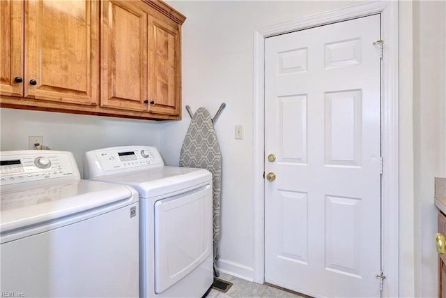 laundry room with baseboards, cabinet space, and washer and clothes dryer