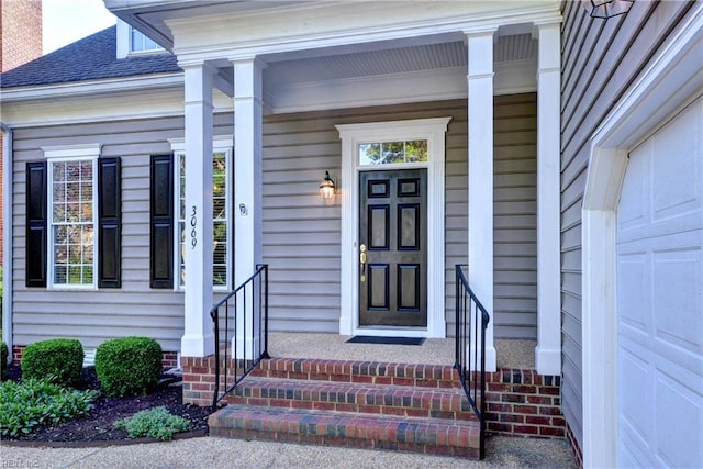 doorway to property with covered porch and a shingled roof