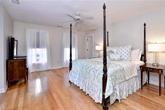 bedroom featuring baseboards, a ceiling fan, light wood finished floors, and visible vents