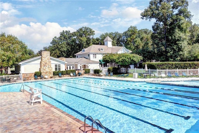 community pool with fence and a patio area