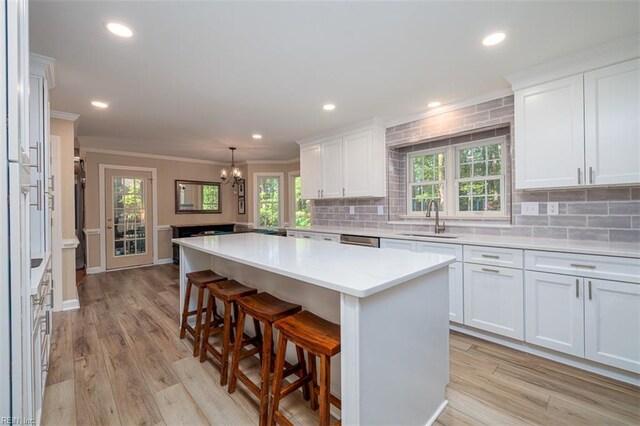 1130 Crystalwood Cir, Chesapeake, VA 23320 - kitchen with crown molding, a sink, light countertops, a chandelier, and backsplash