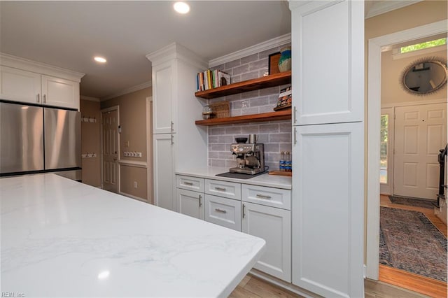 1130 Crystalwood Cir, Chesapeake, VA 23320 - kitchen featuring white cabinets, crown molding, stainless steel refrigerator, light wood-style floors, and tasteful backsplash