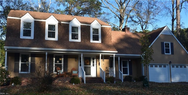 view of front of home featuring an attached garage, roof with shingles, covered porch, and a chimney