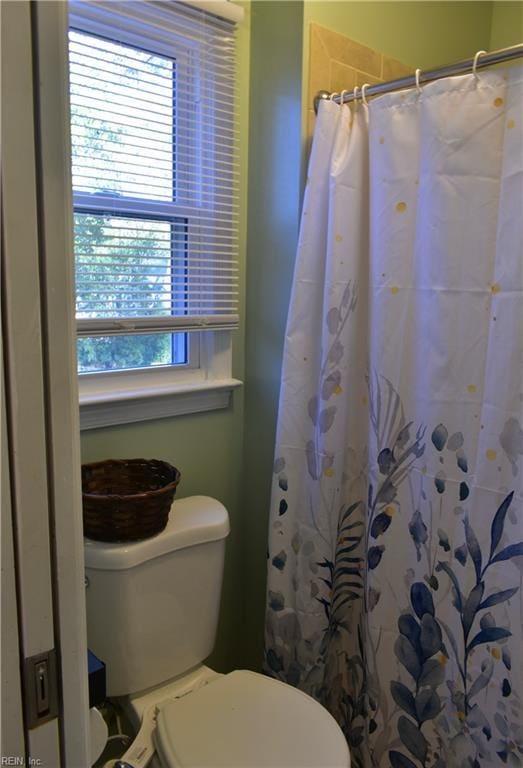 full bath with a shower with curtain and toilet
