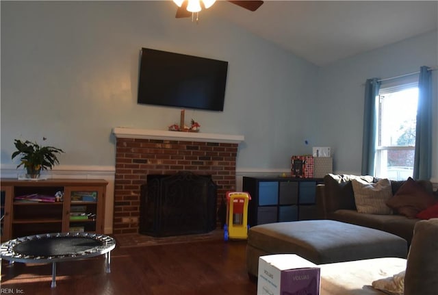living room featuring a brick fireplace, a ceiling fan, wood finished floors, and lofted ceiling